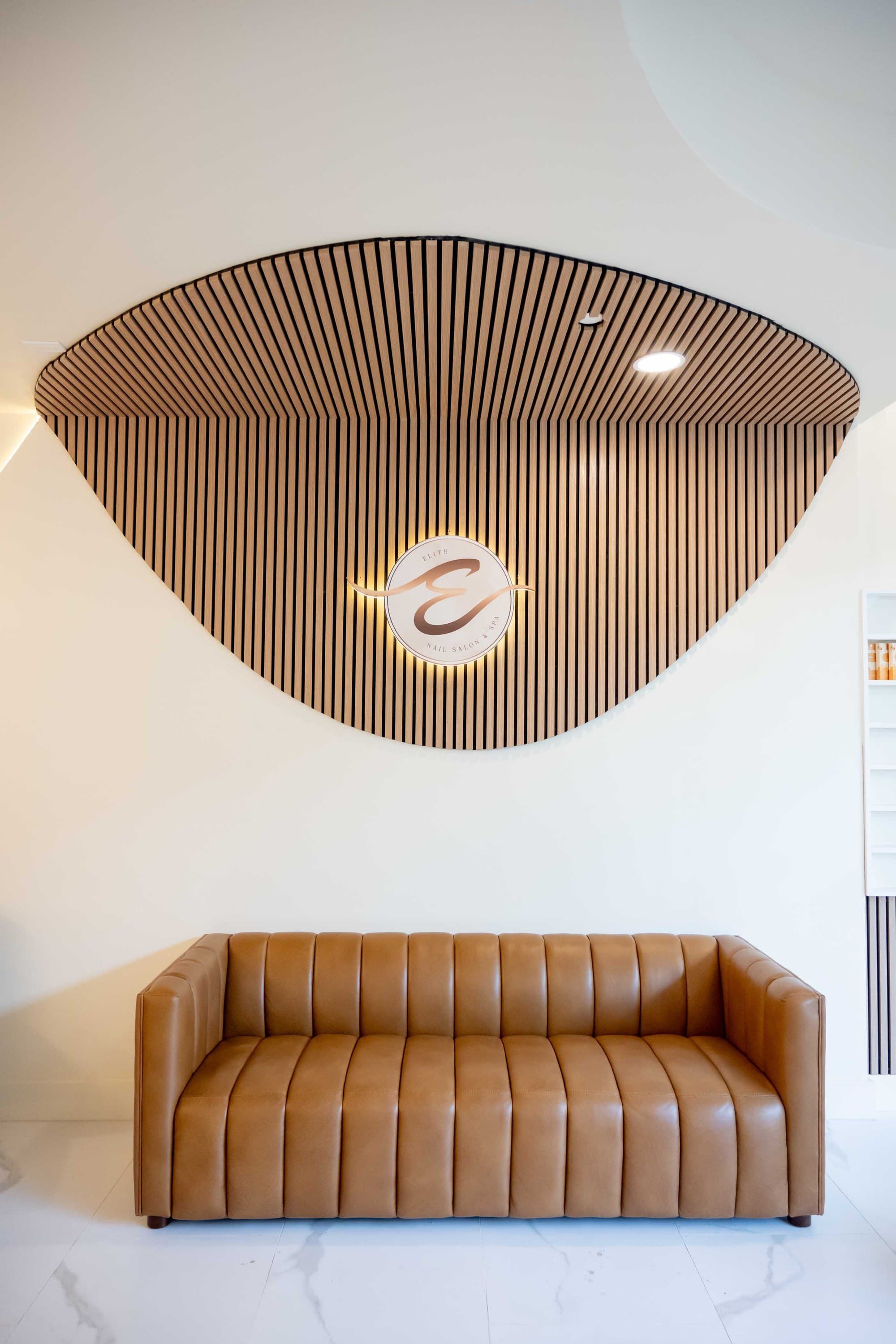Slatted wood wall with the Elite seal at Elite Nail Salon & Spa